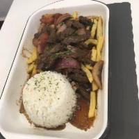 Lomo Saltado · Soft pieces of steak, tomatoes, Peruvian yellow peppers and onions sauteed in a fiery wok. S...