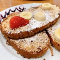 Coconut French Toast · 3 slices garnished with strawberries, bananas, powdered sugar, and blueberry puree. Vegan up...