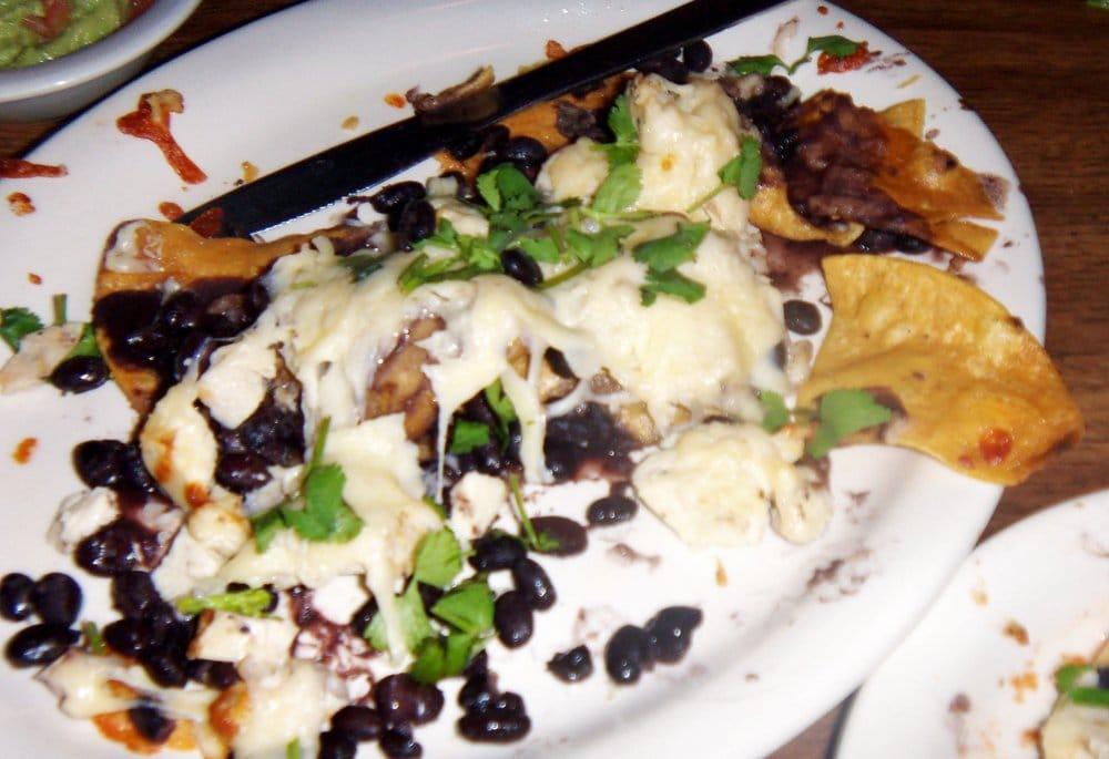 Nachos Azteca · Baked with chihuahua cheese spiced and marinated grilled chicken, black beans and cilantro (available without meat).