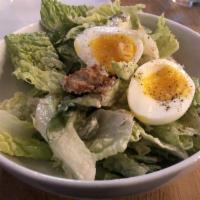 Caesar Salad · Romaine hearts, soft poached egg, castelvetrano olives, Grana Padano, croutons, creamy garli...