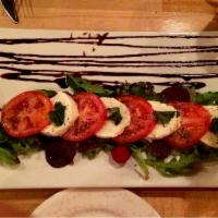 Caprese Salad · Homemade mozzarella, sliced tomatoes, basil and extra virgin olive oil. Vegetarian.