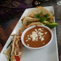 Fish Tacos · Blackened tilapia, poblano rajas, mango salsa, red-chile tomatillo and queso fresco on flour...