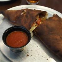 Spinach Pie Calzone · Calzone filled with mozzarella, spinach, pepperoni and roasted garlic. Served with a side of...