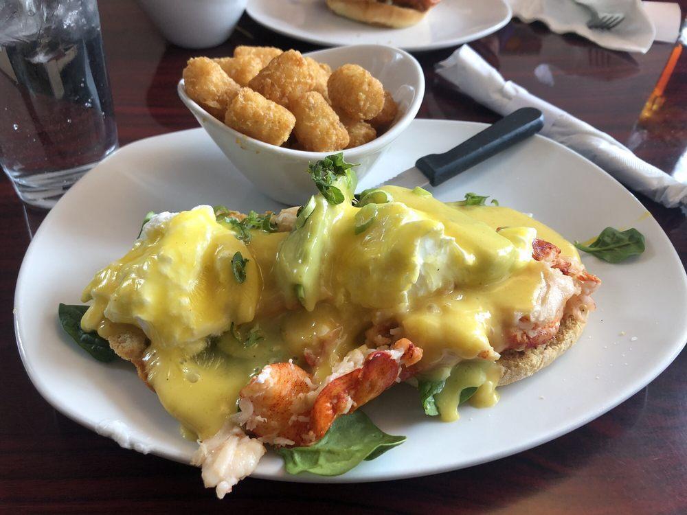 Lobster Benedict · Butter poached lobster and seafood blend, spinach, poached eggs, house hollandaise, scallions, and a buttermilk biscuit.