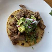 Asada Taco · Savory marinated steak served over our delicious handmade tortilla. Topped with guacamole, c...