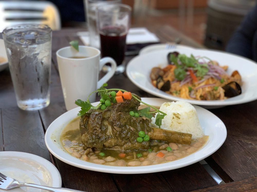 Braised Lamb Shank · Seco de cordero. Contain gluten. Slow Braised lamb shank in cilantro broth with cusqueña beer, garlic, onions and aji amarillo, served with rice and canary bean.