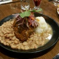 Pork Adobo · Slow simmered pork shoulder in aji panca and spices, Peruvian rice, canary beans, served wit...