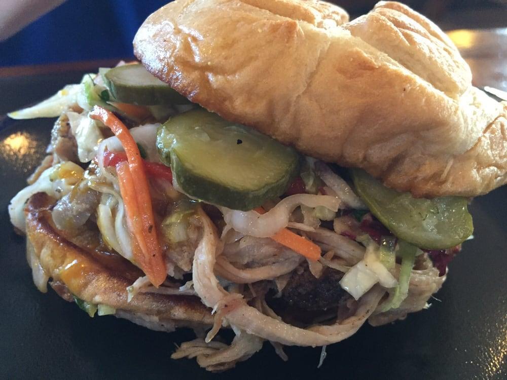 Pulled Pork Sandwich · Pulled pork with gold BBQ sauce, slaw and homemade pickles on a toasted roll.