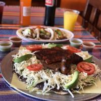 Tlayuda · Oaxacan pizza. A thin crispy handmade corn tortilla smeared with asiento, black beans paste,...