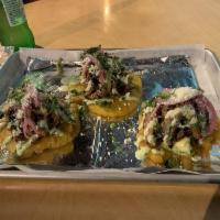 Tostones · 3 plantain tostones topped with ropa vieja (shredded beef), pickled onions, cotija cheese, g...