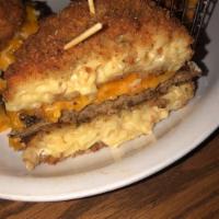 Mac and Cheese Burger · Our homemade gooey mac and cheese is the bun for this 8 oz. brisket/chuck burger. Topped wit...