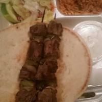 Lamb Kabob · Two skewers of our homemade marinated lamb. Served with rice, salad, pita bread and yogurt s...