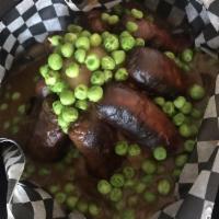 Bangers and Mash · English sausage served over mashed potatoes smothered in gravy, comes with peas.