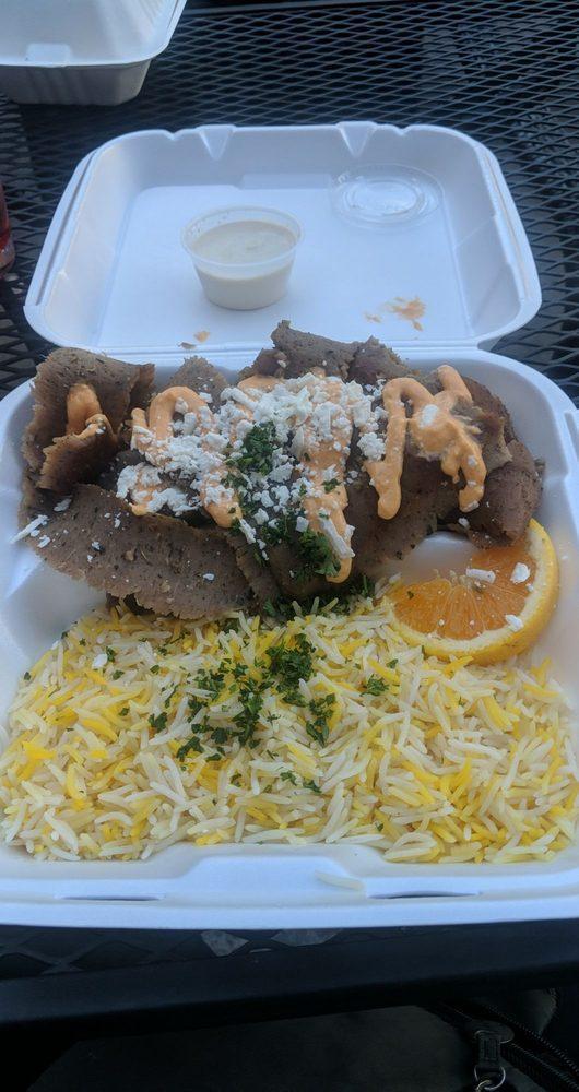 Gyro Plate · Gyro meat (lamb and beef mixture) on a bed of lettuce, topped with feta cheese and spicy garlic sauce. Served with basmati rice. Halal.