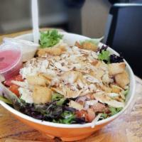 Coconut Chicken Salad · Baked coconut chicken, artichoke hearts, Swiss cheese, tomatoes, red onion, croutons and sli...