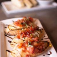 Bruschetta · Fresh tomatoes, goat cheese, basil, shallots, and garlic with a balsamic reduction.