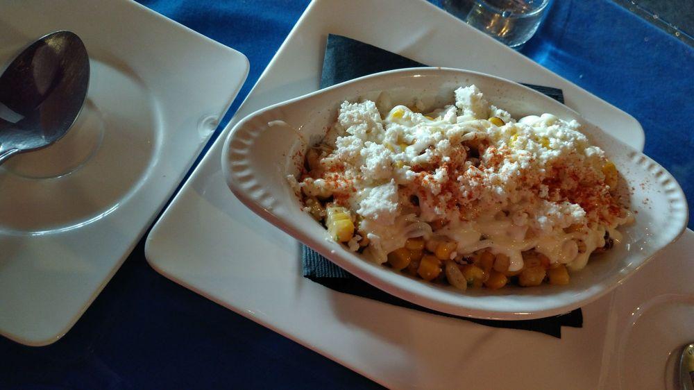 Esquites · Served grilled corn sauteed with salt, lime, red pepper and epazote, topped with sour cream, mayo and queso fresco.