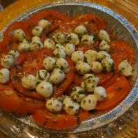 Caprese Salad · Fresh tomatoes, Mozzarella cheese, basil, oregano and extra-virgin olive oil served with bre...