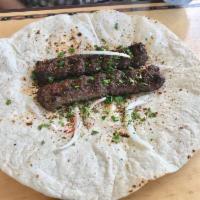 Iraqi Lamb Kebab · 2 kebabs, garnished with parsley, onion, and summuc.