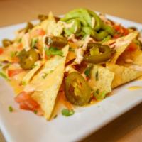 Nachos · Organic white corn chips topped with vegan cheddar cheese sauce, served with guacamole, pico...