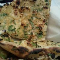 Garlic Naan · Soft bread made with garlic and fresh cilantro,baked in our tandoor.