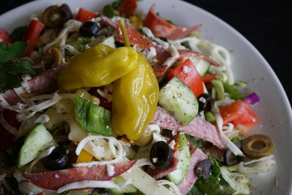 Chopped Antipasto Salad · Capicola ham, Genoa salami, pepperoni, Roma tomatoes, cucumbers, mixed bell peppers, pepperoncinis, black olives, green olives, Swiss, mozzarella, tossed with Streets Italian dressing.