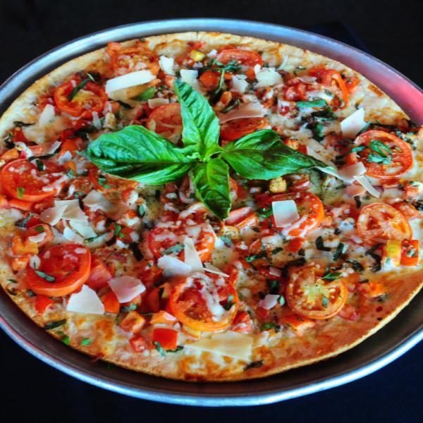 Classic Margherita Pizza · Garlic butter, Roma tomatoes, onions, fresh basil, roasted garlic, pecorino and balsamic vinegar.