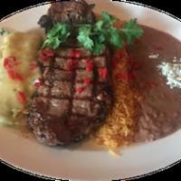 Bistec a la Tampiquena · Grilled tenderloin cooked to your liking. Served with a cheese enchilada verde, rice and bea...