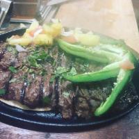 Bistec mi Mi rancho · grilled skirt steak topped with pineapple relish served with rice and beans