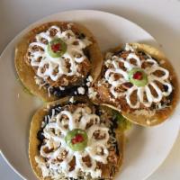 3 Piece Tostaditas · Deep fried corn tortilla topped with beans, salsa, lettuce, sour cream, cheese and guacamole.