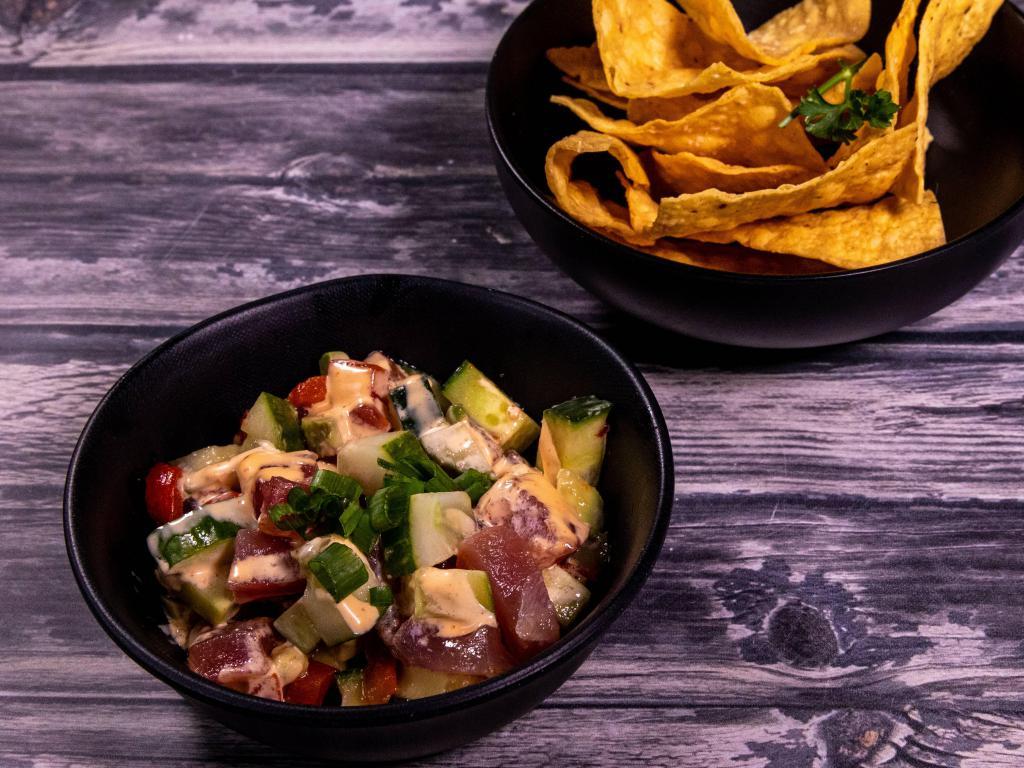 Tuna Ceviche · Sashimi-grade tuna tossed in a soy-lime vinaigrette with avocado, English cucumber and roasted bell pepper topped with spicy aioli served with tostadas.