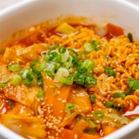 D2. Ramyun Dukbokki · Rice cakes, ramyun, fish cake, cabbage, carrot, scallions and sesame in hot sauce. Spicy.