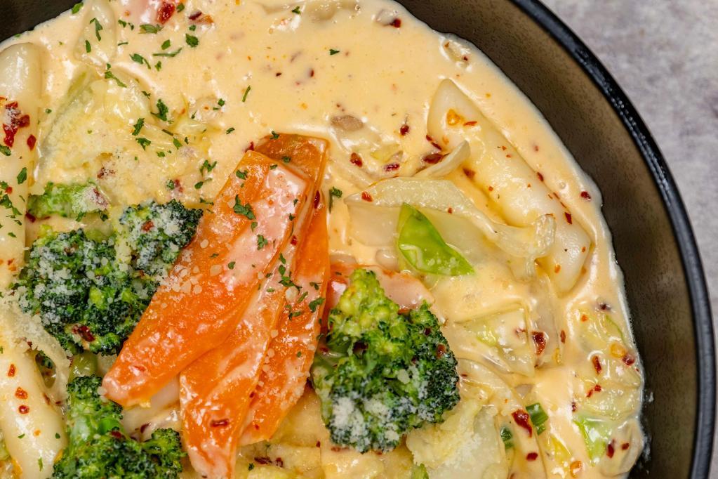Spicy Cream Dukbokki · Rice cakes, red pepper seed, heavy cream, broccoli, cabbage, onions, garlic, carrot, parsley, sesame, and Parmesan cheese. Spicy.