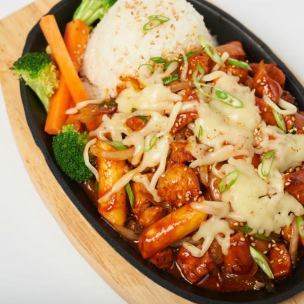 Bull Dak · Spicy chicken stir-fried with rice cakes and Bonchon Signature Hot Sauce, sauteed onions, topped with thinly-sliced scallions and mozzarella cheese. Served with white rice and steamed vegetables.