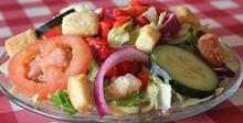 Dinner Salad · Fresh and crisp iceberg and romaine lettuce topped with tomato, cucumber, red onion, diced red peppers and herbed croutons.