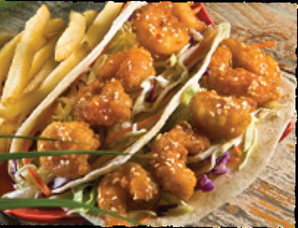 Firecracker Shrimp Tacos · Lightly-fried shrimp tossed in our Firecracker sauce. Served in two flour tortillas with our Garlic Ginger Slaw and garnished with sesame seeds.