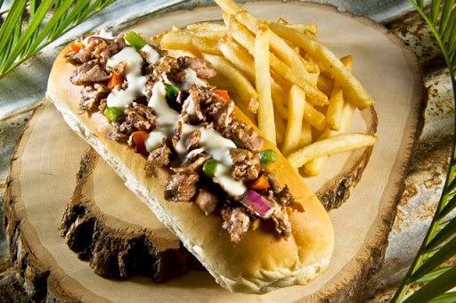 Steak Philly · Thinly sliced grilled steak piled high with sautéed grilled onions and peppers then topped with melted American cheese and served on a toasted hoagie roll.