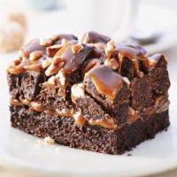 Rockslide Brownie · Delicious light textured brownie topped with butter-lucious caramel, piled high with brownie...