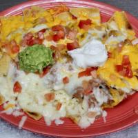 Chicken Nachos · Shredded chicken on bed of chips. Topped with beans and tomatoes. Served with sour cream and...