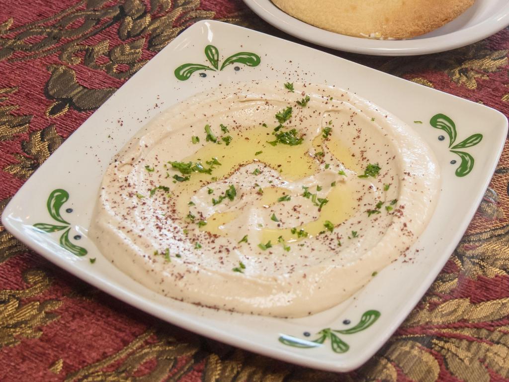 Hummus · Garbanzo beans boiled and blended with tahini sauce, lemon and served with olive oil. Served with fresh baked pita bread.