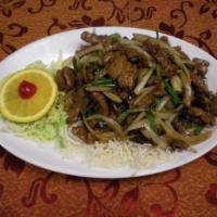 Mongolian Beef · Sliced tender flank beef tossed with scallion and yellow onion bedded on crispy rice noodle....