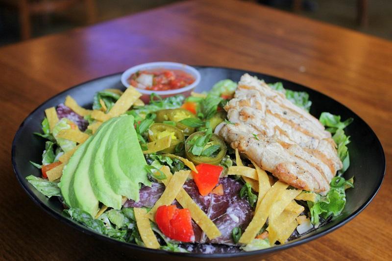 Southwest Chicken Salad · All-natural chicken breast, fresh greens, black beans, diced tomato, corn tortilla chips, and shredded Jack and cheddar cheeses tossed in salsa ranch dressing. Topped with jalapenos, avocado, diced red pepper, green onion, and cilantro. Served with a side of house-made salsa.