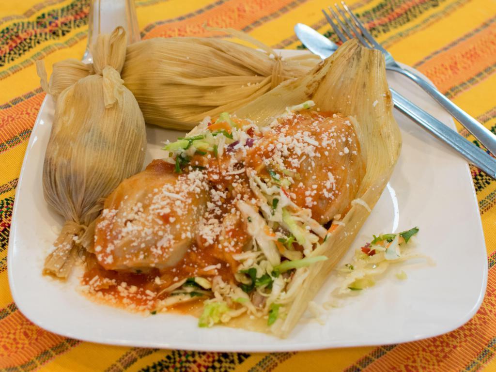 Chuchitos de Pollo · Traditional Guatemalan corn flour cakes filled with chicken. Topped with cabbage salad, tomato sauce and sprinkles of fresh cheese.