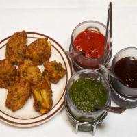 Onion Pakoras · Six pieces. Onions dipped in spiced gram flour, fried. Vegetarian. Gluten-free. Served with ...