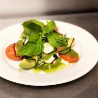 Caprese Salad · Fresh mozzarella and tomato slices with fresh basil and a drizzle of extra virgin olive oil.
