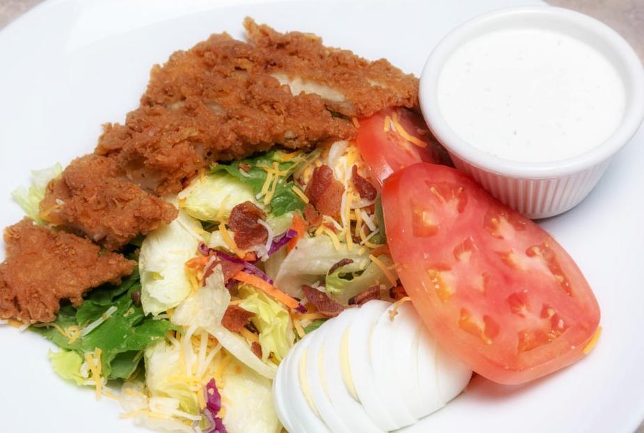 Crispy Chicken Salad · Regular or buffalo style. Our tender fried chicken strips with a hard boiled egg, bacon, shredded cheddar and jack cheese tomato slices on generous bed of greens. Served with choice of salad dressing.