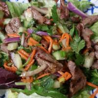 21. Beef Salad · Grilled beef mixed with tomatoes, crushed toasted rice, cucumbers, lemongrass, mint leaves, ...