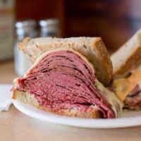 The Overstuffed New Yorker Sandwich · Hot corned beef and hot pastrami,  melted Swiss cheese and Russian dressing. Served with col...