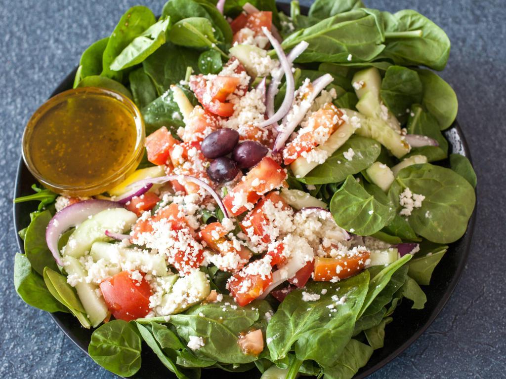 Spinach Salad · Spinach, onion, tomato, cucumber, feta and olives tossed in our olive oil vinaigrette.