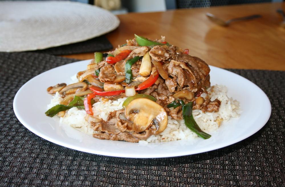Beef Teriyaki over Baked Rice · Thinly sliced teriyaki beef stir fried with bell peppers, mushrooms, and onion, served over light fried rice with egg and onion.